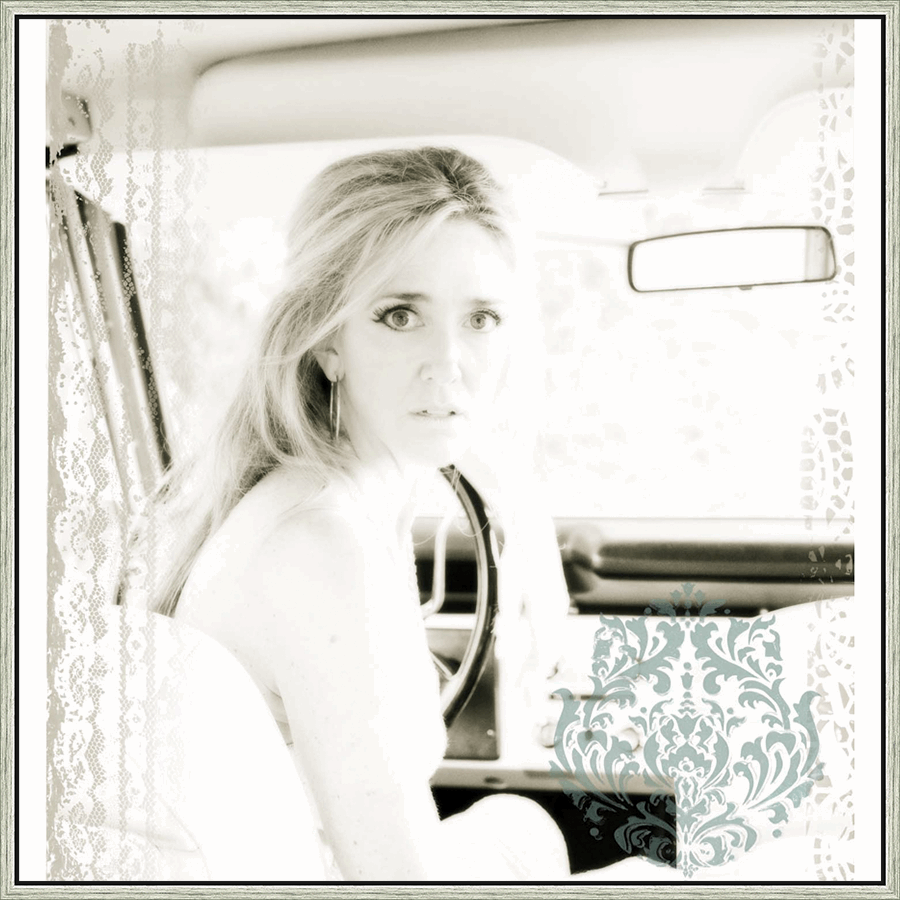 A captivating black and white image captures a woman sitting inside of a car, gazing directly at the viewer with a look of intrigue. Soft focus and a delicate aesthetic gives the piece a vintage quality. The artwork's monochrome treatment enhances the emotional depth of the scene, while decorative embellishments provide a sense of timeless elegance.