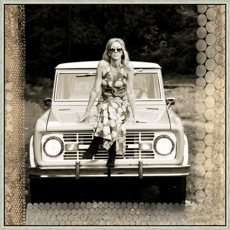 A striking sepia-toned photograph portrays a woman perched atop a vintage SUV, exuding an air of relaxed confidence. Her stylish attire, sunglasses, and boots blend with the classic vehicle, creating a timeless scene. The background offers a backdrop of lush trees, adding depth to the image, making this piece an eye-catching addition to any art collection.